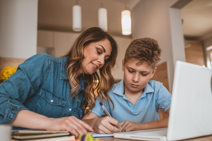 Learner and their parent looking at a computer during a virtual session.